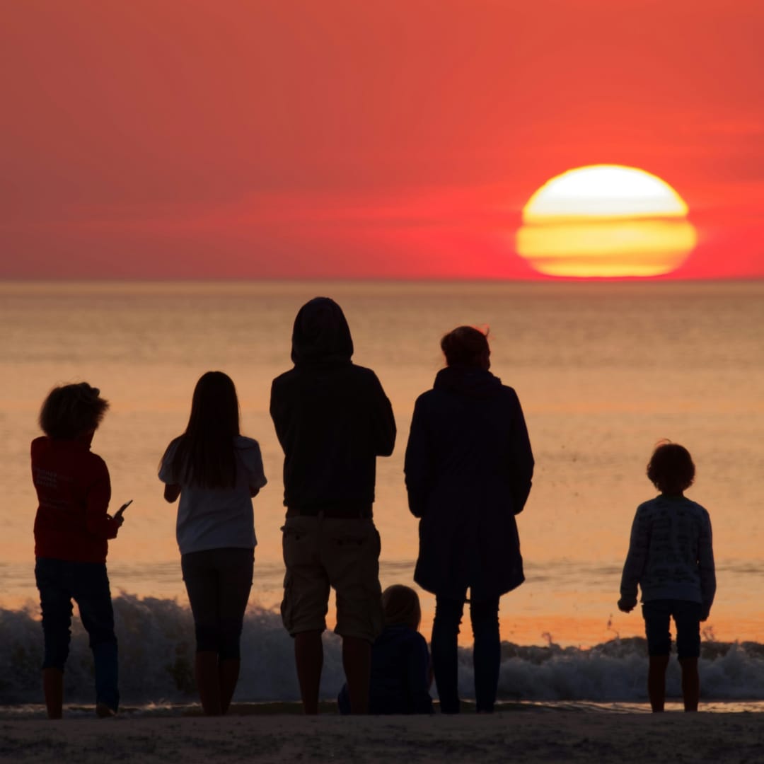 Friends & family enjoying sunset on a beach